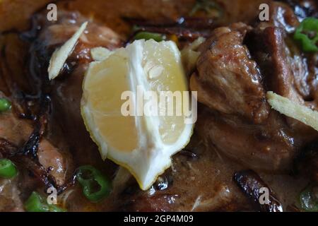 Nahaufnahme des traditionellen pakistanischen Haleem-Gerichts mit Salat und Zitronensaft. Stockfoto