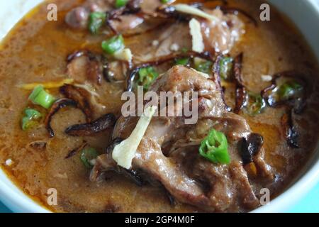 Nahaufnahme des traditionellen pakistanischen Haleem-Gerichts mit Salat und Zitronensaft. Stockfoto