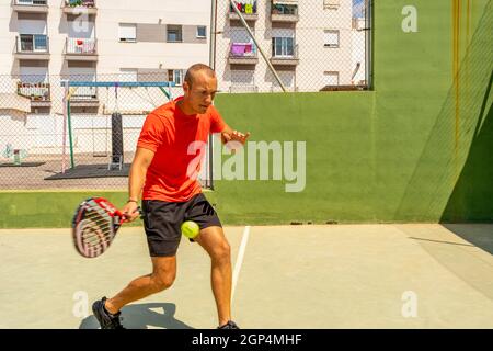 Burriana, Spanien 06-01-2021: Kaukasischer junger Mann mit Sportbekleidung, der Paddle-Tennis spielt Stockfoto