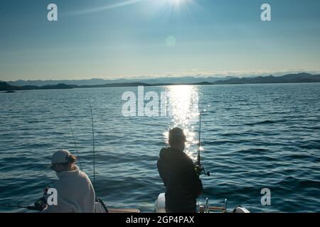 Paar mit Angelrute auf einem Boot im Meer in der Nähe von Stavanger Norwegen (Jig Angeln) Stockfoto