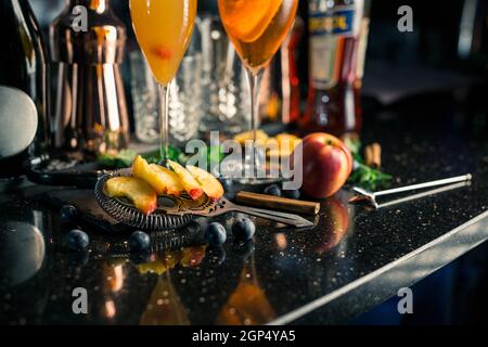 Mehrere alkoholische Cocktails an der Bar in verschiedenen Gläsern. Cocktaildekoration: Limette, Minze, Orange, Sirup. Stockfoto