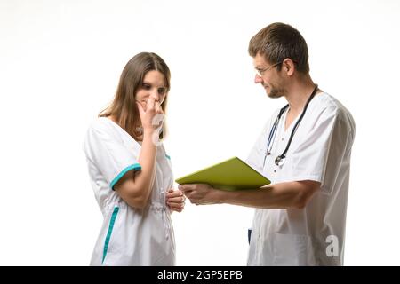 Der Arzt zeigt dem Pflegepersonal den Fehler bei der Verschreibung des Patienten an Behandlung Stockfoto