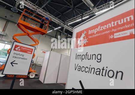 Köln, Deutschland. September 2021. Ein Arbeiter entfernt in einer Ausstellungshalle des Impfzentrums Köln Elektrokabel. Quelle: Henning Kaiser/dpa/Alamy Live News Stockfoto