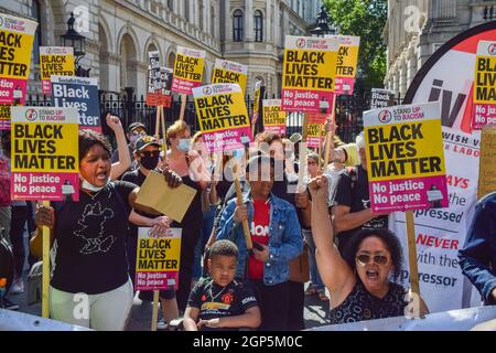 Demonstranten nehmen das Knie und halten Plakate mit Black Lives Matter. Demonstranten hielten Reden und knieten vor der Downing Street in Solidarität mit den englischen Fußballspielern Marcus Rashford, Bukayo Saka und Jadon Sancho, nachdem das Trio nach dem EM 2020-Finale zwischen England und Italien rassistische Online-Misshandlungen erhalten hatte. London, Großbritannien. Juli 2021. Stockfoto