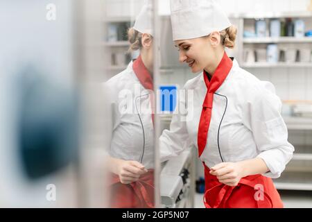 Kochen Sie in großen kommerziellen Küche Rührsoße Blick auf Kamera Stockfoto