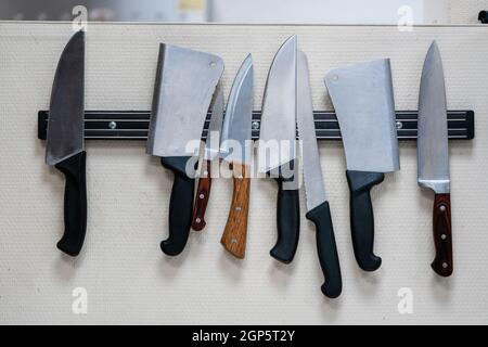 Ein Set aus Edelstahl-Besteck, das an einer Küche hängt Wand Stockfoto