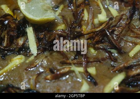 Nahaufnahme des traditionellen pakistanischen Haleem-Gerichts mit Salat und Zitronensaft. Stockfoto