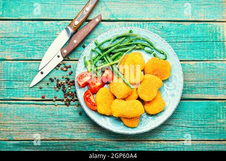 Köstliche gebratene Hähnchennuggets mit Kuhpfeiben auf dem Teller Stockfoto