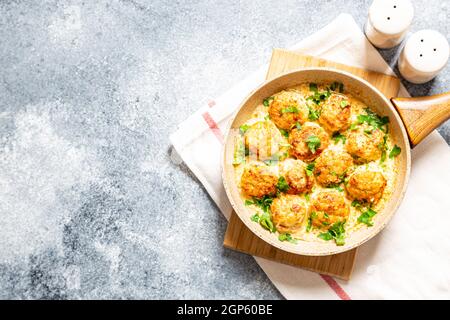 Fleischbällchen in weißer Soße in einer Pfanne auf grauem Hintergrund, bequeme hausgemachte gesunde Lebensmittel Stockfoto