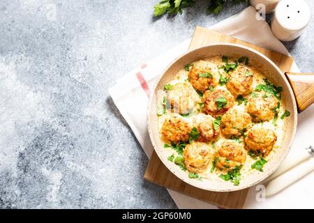 Fleischbällchen in weißer Soße in einer Pfanne auf grauem Hintergrund, bequeme hausgemachte gesunde Lebensmittel Stockfoto