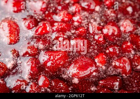 NAHAUFNAHME: Erdbeermarmelade. Machen Sie eine Erdbeermarmelade. Erdbeeren in der Pfanne kochen. Prozess des Kochens, kochende Beeren für das Einkochen. Gesunde, süße Speisen. Co Stockfoto