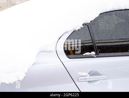 Fallen schlafend nassem Schnee Auto. Schneefall von nassem Schnee. Schnee liegt auf dem Auto. Stockfoto