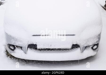 Fallen schlafend nassem Schnee Auto. Schneefall von nassem Schnee. Schnee liegt auf dem Auto. Stockfoto