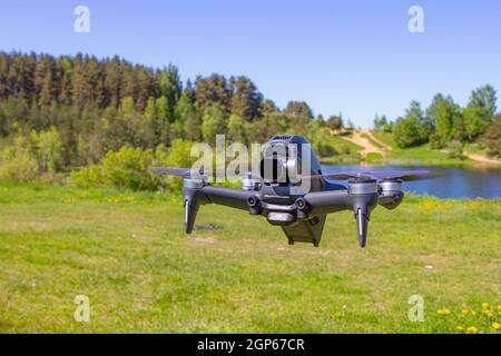 Moskau, 31. MAI 2021 : Eine neue DJI FPV-Drohne fliegt an einem sonnigen Tag auf Gras im Beckground. Vorderansicht Von Oben. Headless Quadcopter mit Digital 4K 60 Stockfoto