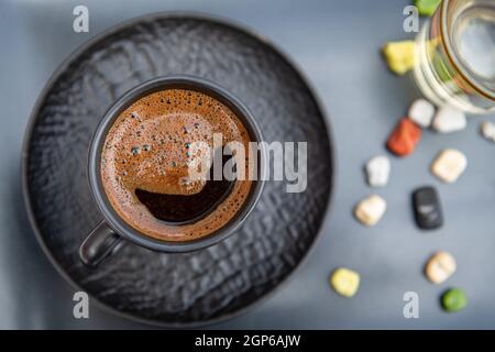 Traditioneller türkischer Kaffee in einer modernen schwarzen Tasse mit Wasser und Zucker. Selektiver Fokus Stockfoto