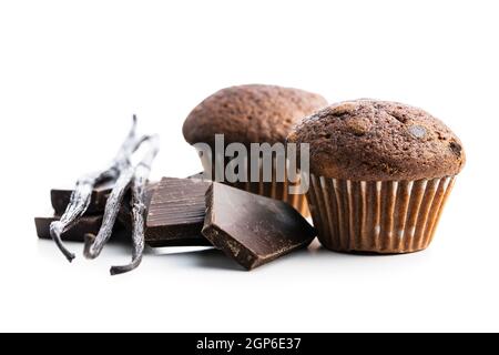 Schokoladen-Muffins mit Schokoriegel und Vanilleschoten. Süße dunkle Cupcakes isoliert auf weißem Hintergrund. Stockfoto