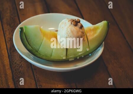 Fruchtiges Melon Dessert, gekrönt mit Vanilleeis Stockfoto