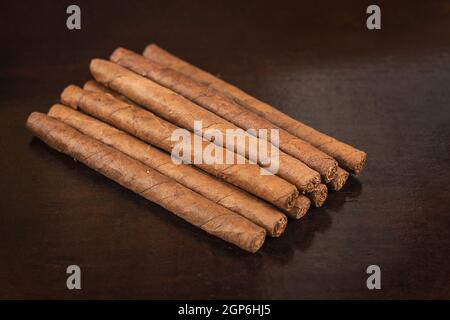 Eine Gruppe von neun kleinen Zigarren auf einem Tisch Stockfoto