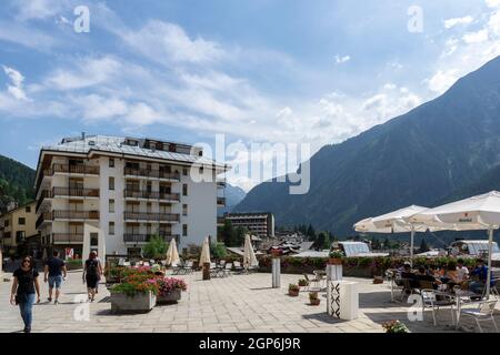 Courmayeur, Italien - August 24 2021: Restaurant oder Café mit Außenbereich in Norditalien. Sonnenschirme, Sonnenschirme mit Tisch und Stühlen und Berg Stockfoto