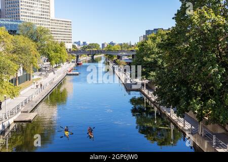 Ottawa, Kanada - 19. September 2021: Rideau-Kanal mit Booten und Menschen, die am sonnigen Sommertag entlang des Damms in der Innenstadt von Ottawa spazieren Stockfoto