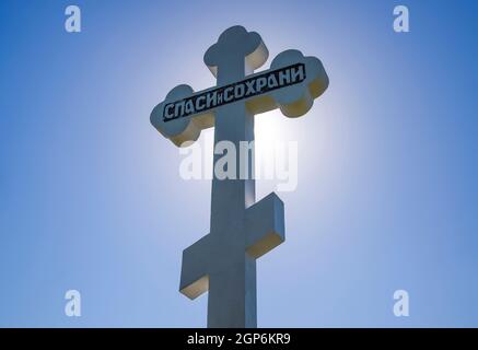 Krasnodar, Russland - 29. April 2017: Orthodoxe Kreuz gegen den blauen Himmel und die Sonne. Kreuz im Gegenlicht der Sonne. Symbol des christlichen Glaubens. Stockfoto