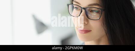 Porträt einer jungen, nachdenklichen Geschäftsfrau in einer Brille mit Blick aus dem Fenster Stockfoto