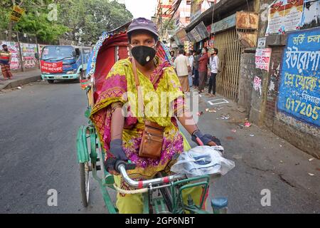 Eine weibliche Rikscha-Reiterin. Das Land hatte mehrere Sperren, um die Ausbreitung des Coronavirus einzudämmen. Dhaka, Bangladesch. Stockfoto