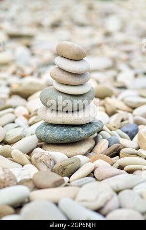 In einem Garten ragen Kieselsteine aus dem Meer. Nahaufnahme von gestapelten balancierten Jack-Stones. Stockfoto