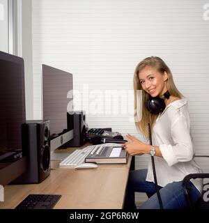 Der Toningenieur überprüft vor Beginn der Arbeiten die Richtigkeit des Audiorecorders. Atmosphäre produziert Musik in einem professionellen Aufnahmestudio. Stockfoto