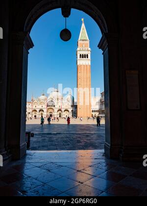 Blick durch einen Torbogen auf den Markusplatz mit dem Campanile-Glockenturm und der Markusbasilika, San Marco, Venedig, Venetien, Italien Stockfoto