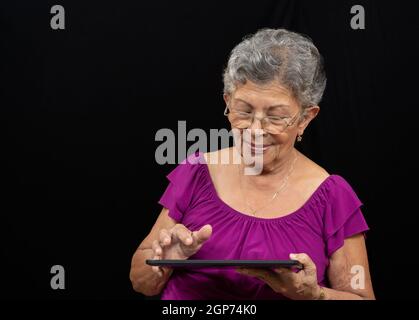 Ältere Frau mit Brille mit einem Tablet Stockfoto