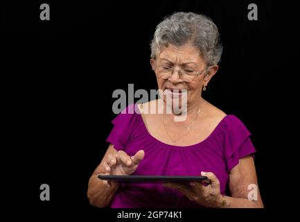 Ältere Frau mit Brille mit einem Tablet Stockfoto