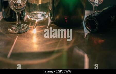 Lichtreflexe aus verschiedenen Weinflaschen und Gläsern auf Holztisch. Speicherplatz kopieren. Stockfoto