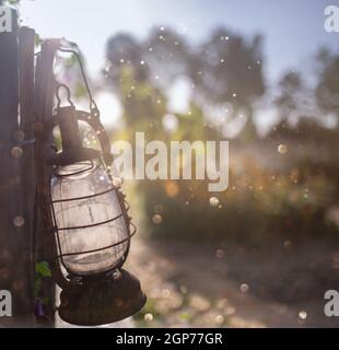 Hintergrund alten Holzzaun mit klassischen antiken Lampen hängen Dekorationen in der Morgenlicht. Stockfoto