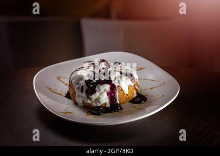 Authentische rumänische Käse Donuts namens Papanasi mit Quark gemacht Und garniert mit saurer Sahne und mit Preiselbeermarmelade Belag Stockfoto