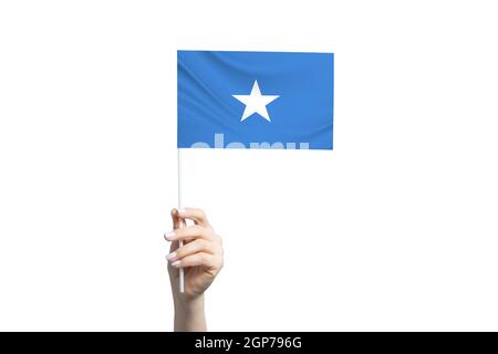 Schöne weibliche Hand hält Somalia Flagge, isoliert auf weißem Hintergrund. Stockfoto