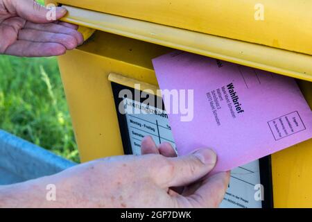 Der Umschlag mit postalischen Stimmdokumenten für die Bundestagswahl am 26.09.2021 wird in einem Briefkasten, Bayern, Deutschland, platziert Stockfoto