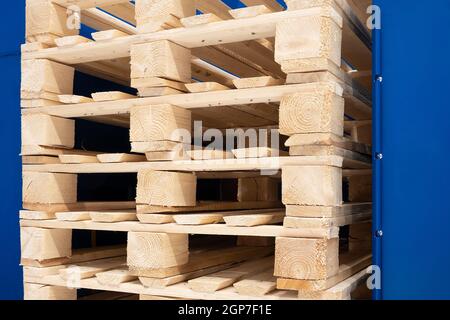 Viele Stapel gebrauchter Holzpaletten vom Typ Euro im Lager sind für das Recycling bereit. Industrieller Hintergrund. Nahaufnahme. Stockfoto