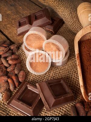 Kapseln von Schokolade mit Kakao-Pulver, Kakaobohnen und Schokolade. Stockfoto