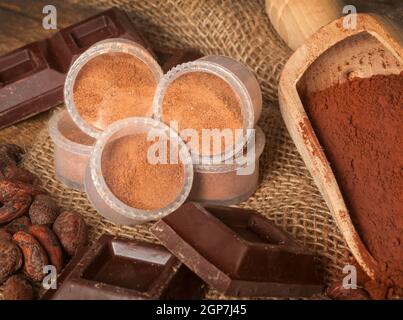 Kapseln von Schokolade mit Kakao-Pulver, Kakaobohnen und Schokolade. Stockfoto