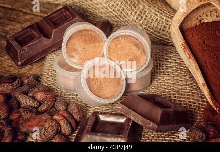 Kapseln von Schokolade mit Kakao-Pulver, Kakaobohnen und Schokolade. Stockfoto