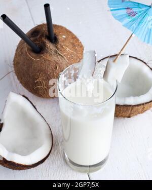 Spalsh Getränk mit Milch und Kokos auf weißer Holztisch. Stockfoto