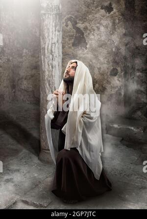 Jesus Knien im Gebet in Richtung des Lichts. Stockfoto