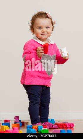 Kleinkind baby girl spielt mit weichem Gummi Bausteine. Stockfoto