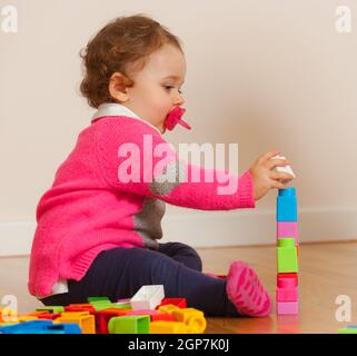 Kleinkind baby girl spielt mit weichem Gummi Bausteine. Stockfoto