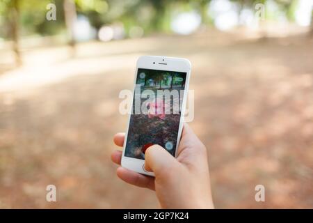 Empoli, Italien - 26. Juli 2016: Nintendo Pokemon WIRD AUGMENTED Reality-Smartphone. Der Spieler im Park mit der Hand berührt den Bildschirm, während er fängt Stockfoto