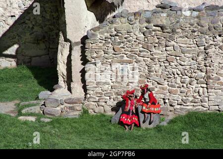 Zwei einheimische Mädchen in traditioneller Kleidung in den inkanischen Ruinen von Ollantaytambo im Heiligen Tal, Peru Stockfoto