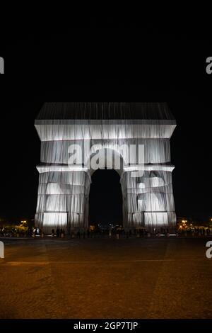 Blick auf den gewickelten Triumphbogen von Christo in Paris bei Nacht. Stockfoto