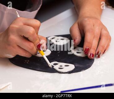 Gebäck Lektion, die auf Zahlen von Halloween mit Fondant einfügen oder Zuckerpaste. Stockfoto