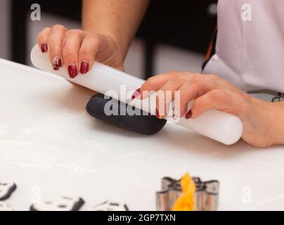 Gebäck Lektion, die auf Zahlen von Halloween mit Fondant einfügen oder Zuckerpaste. Stockfoto